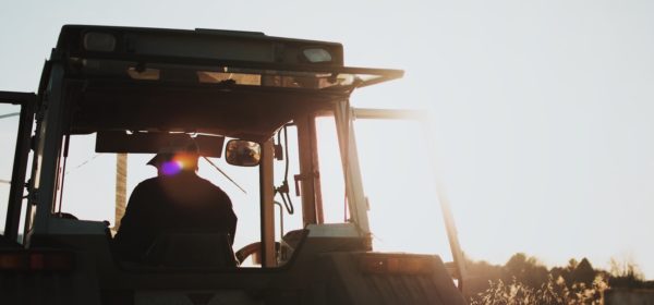 Un agriculteur sur son tracteur labourant son champ